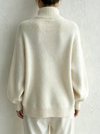 Ivory turtleneck sweater worn with wide-leg trousers, full-length shot