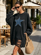 Close view of the frayed denim star patch on the sweatshirt dress