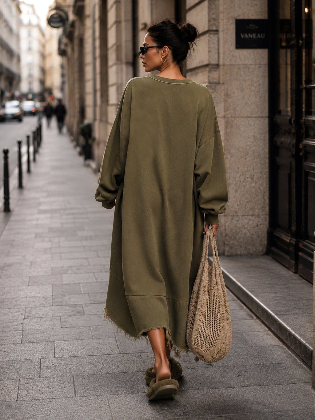 Raw frayed hem and ribbed cuffs of the oversized sweatshirt dress