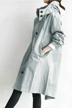 Waterproof hooded raincoat worn open over a sweater, side view