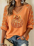Orange Halloween blouse with pumpkin and bow print, V neck and 3/4 sleeves