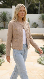 Beige cropped jacket in motion, showing the waist-length cut